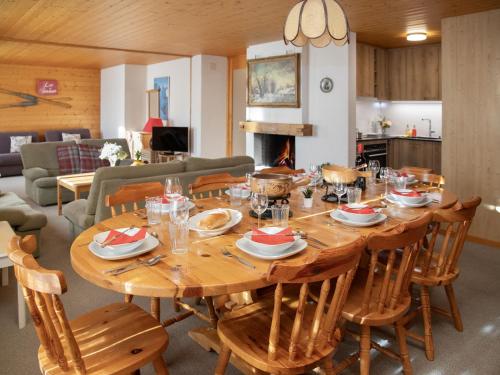 een grote houten tafel met stoelen en een eetkamer bij Apartment Chäs Gruebi Apt-S by Interhome in Wengen