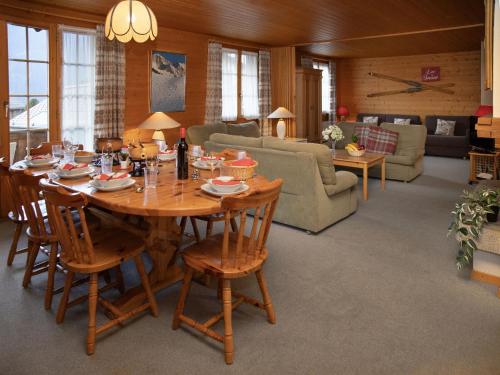 a living room with a wooden table and chairs at Apartment Chäs Gruebi Apt-S by Interhome in Wengen