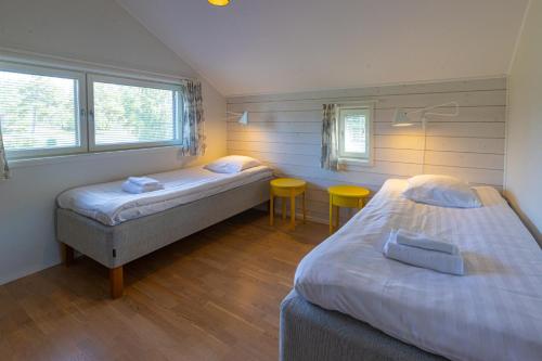 a room with two beds and a table in it at Käringsund Resort in Eckerö