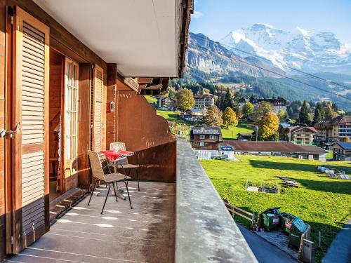 a balcony with a table and a view of mountains at Apartment Chäs Gruebi Apt-S by Interhome in Wengen
