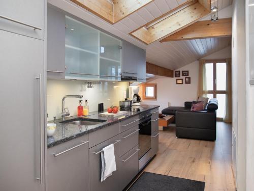 a kitchen with stainless steel appliances and a living room at Apartment Breithorn Residence Apt-09 by Interhome in Wengen