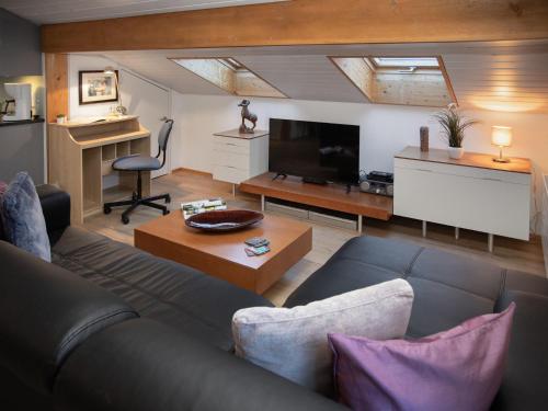 a living room with a couch and a tv at Apartment Breithorn Residence Apt-09 by Interhome in Wengen