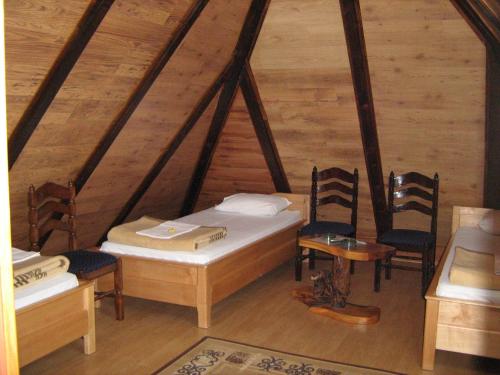 Cette chambre mansardée comprend 2 lits et des chaises. dans l'établissement SOBE za izdavanje BLEF, à Ovčar Banja