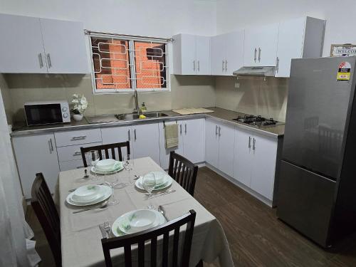 a kitchen with a table with plates on it at Cosy Homes in Suva - 2BR Family Unit in Suva