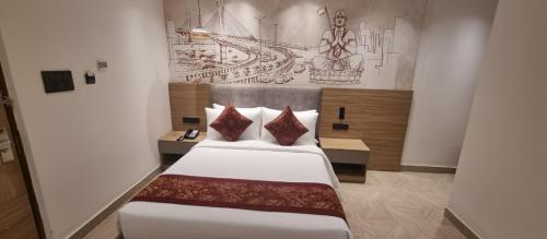 a bedroom with two beds and a painting on the wall at Klyra Hotel in Hyderabad