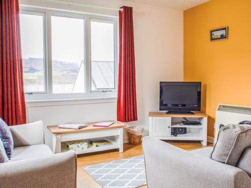 a living room with a tv and two chairs at Holiday Home Alan's House by Interhome in Staffin