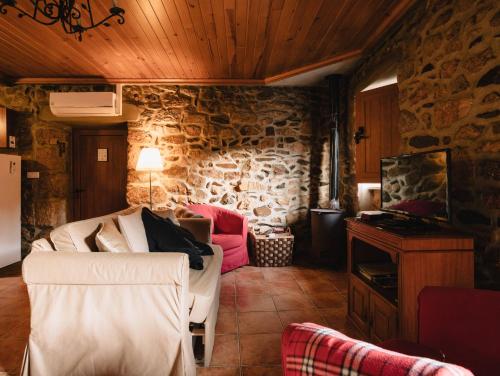 a living room with a couch and a stone wall at Quinta de Recião in Lamego