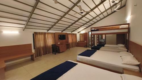 a hotel room with two beds and a tv at GM Farm Mountain View Homestay in Avathi
