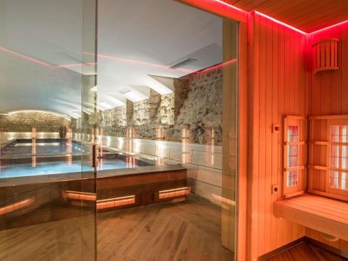 a swimming pool in a building with red lighting at MADISON Saint Jean de Luz - Handwritten Collection in Saint-Jean-de-Luz