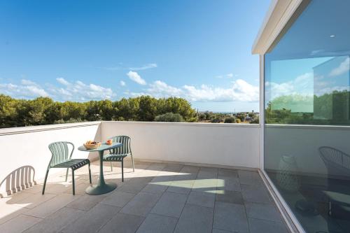 莫诺波利HelloAPULIA Villa Annita - Enchanting Sea-View Villa - superb location 2 minutes from beach and restaurants的阳台上配有桌椅的露台