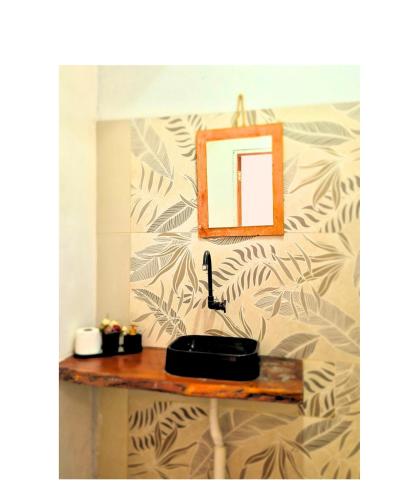 a bathroom with a sink and a mirror on a wall at Hospedaria Caripí in Barcarena