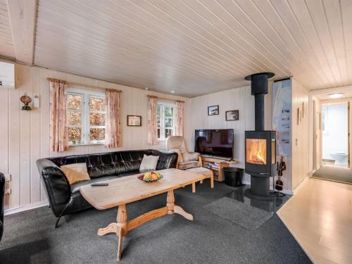 Una sala de estar con un sofá y una chimenea. en Holiday Home Brawith - 700m to the fjord by Interhome, en Ringkøbing