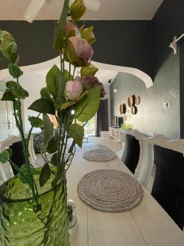 a vase with flowers on a table in a room at B4 Apartment Stone Town in Zanzibar City