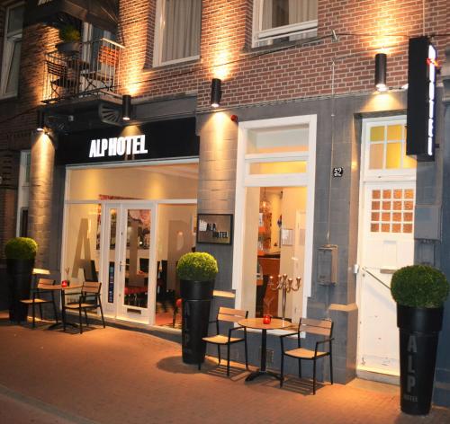 a store with tables and chairs in front of a building at Alp Hotel in Amsterdam