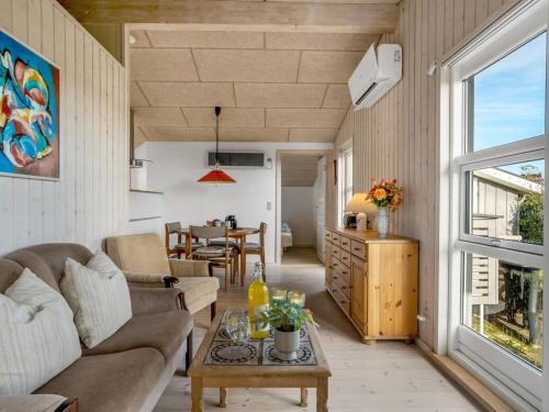 a living room with a couch and a table at Holiday Home Skarthi - 200m from the sea by Interhome in Sæby