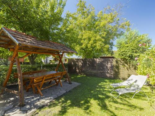 einem Picknicktisch aus Holz und einem Stuhl im Hof in der Unterkunft Apartment Pajtas 1 by Interhome in Balatonfenyves