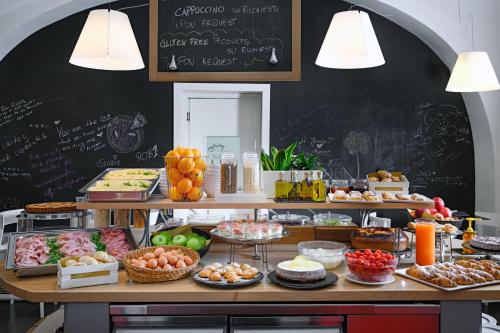 a bakery with a table filled with different types of food at Hotel Piazza Bellini & Apartments in Naples