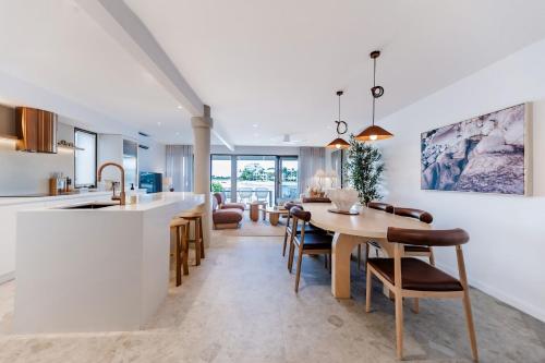 une cuisine et une salle à manger avec une table et des chaises dans l'établissement Bella Vista Noosa Luxury on White Sands, à Noosaville