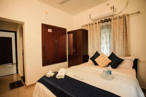 阿勒皮Sukhalaya Lake Villa的一间卧室，里面有一张白色床，窗外是一扇窗户。