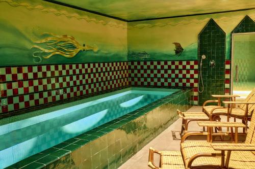 Hôtel Les Deux Gares & Spa في باريس: مسبح في غرفة مع كراسي ومسبح