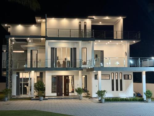 a large white house with a balcony at night at Shrek Villa in Balapitiya
