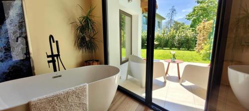 een badkamer met een bad en een tafel en stoelen bij Las Mareas de Llanes in Andrín