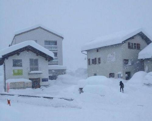 a couple of buildings covered in snow in front at Cad Maté 2 in Maloja
