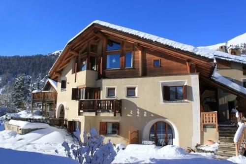 una casa grande con nieve en el suelo en Chardun, en Celerina