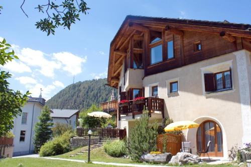 a house with two umbrellas in front of it at Chardun in Celerina