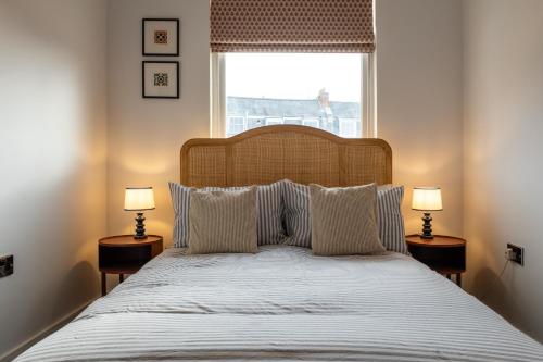 a bedroom with a large bed with two lamps at Stunning High Street Hideaway in Cheltenham in Cheltenham