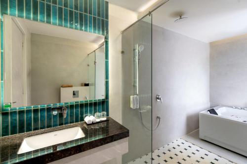 Un baño con ducha, lavabo y espejo. en Champion Prime-My Downtown Hotel, en Udaipur