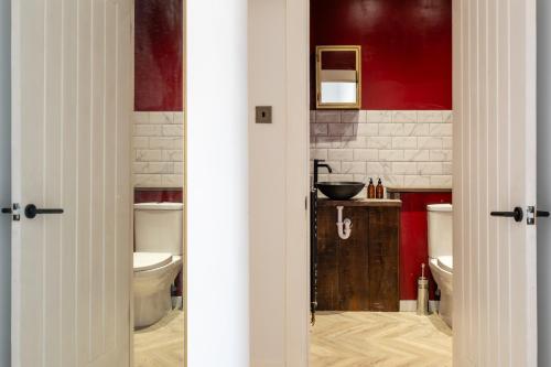 a bathroom with two toilets and a sink at Stunning High Street Hideaway in Cheltenham in Cheltenham
