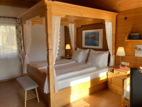 a bedroom with a canopy bed in a cabin at Haus Werner, Ferienwohnung mit Sommercard in Ramsau am Dachstein