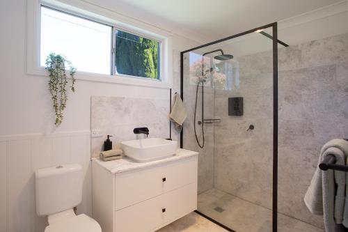 une salle de bain avec douche, lavabo et toilettes dans l'établissement Highlands Heart Cottage, à Bowral