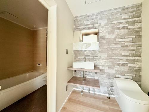 a bathroom with a toilet and a sink and a bath tub at The Lobs 5, Rusutsu in Kimobetsu