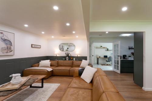 a living room with a couch and a table at Highlands Heart Cottage in Bowral