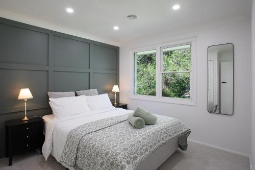 une chambre avec un grand lit et une fenêtre dans l'établissement Highlands Heart Cottage, à Bowral