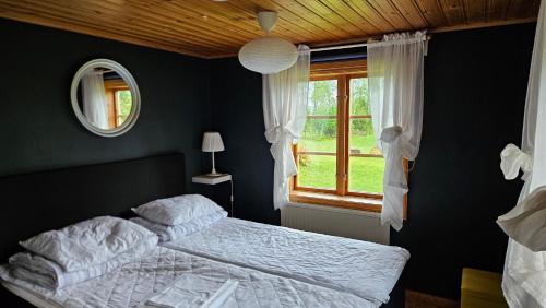 a bedroom with a bed and a window at Kilsborgs Gård - Lakehouse in Svanskog
