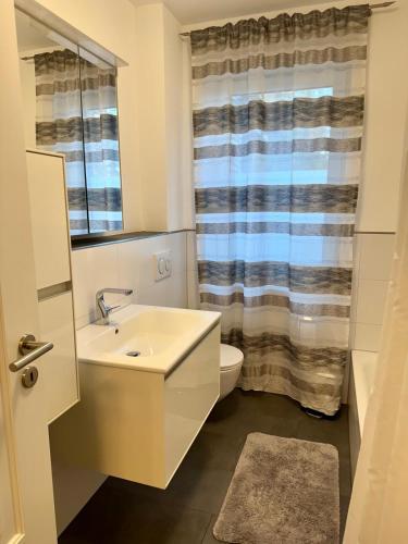 a bathroom with a sink and a toilet and a window at Schöne Wohnung 1 in Buchholz in der Nordheide