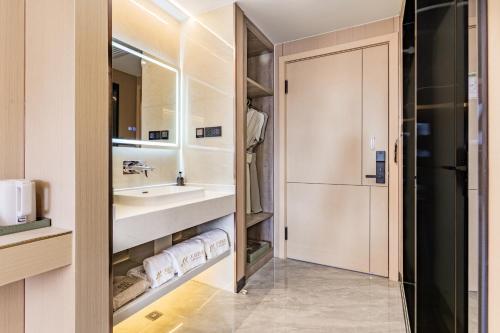 a bathroom with a sink and a mirror at Tiancheng Hotel Liangjiahe Metro Station Branch in Kunming