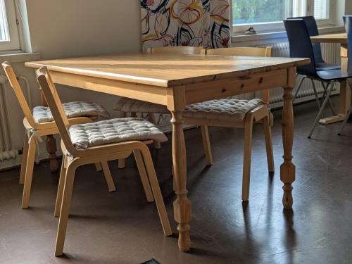 a wooden dining table with two chairs around it at Grand Hostel Ivalo in Ivalo