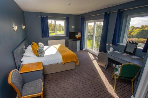 a bedroom with a bed and a desk and windows at Bells Hotel in Coleford