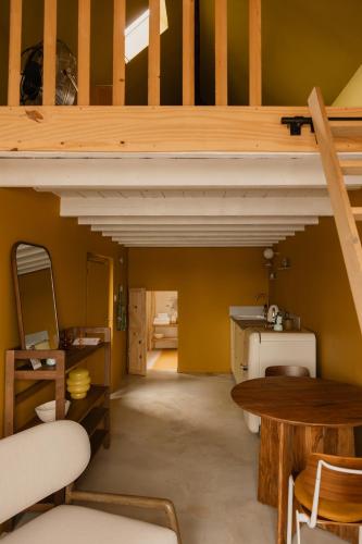 a room with a loft with a staircase and a table at La Maison Plûme in Villequier