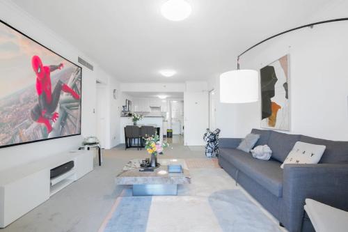 ein Wohnzimmer mit einem blauen Sofa und einem Fernseher in der Unterkunft The Arcadia in CBD w Parking Desk Gym Pool in Sydney
