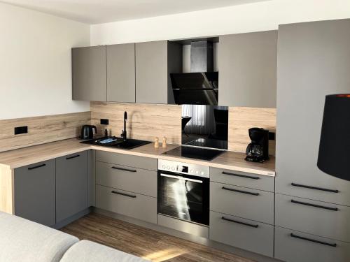 a kitchen with white cabinets and a stove top oven at WeberHof Appartements in Burg