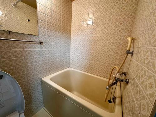 a bathroom with a bath tub and a toilet at 2-6大通駅まで地下鉄で4駅の場所で美室のリフォーム済みアパートメント in Sapporo