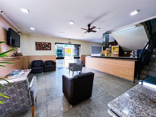 a lobby with chairs and a bar in a hospital at Colonial Hotel in Campo Grande