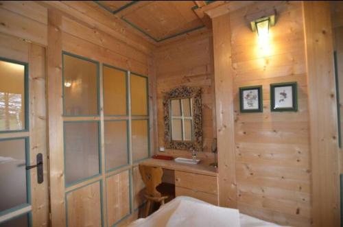 a bathroom with a sink and a mirror in a cabin at Ca' degli Scoiattoli in Cortina dʼAmpezzo