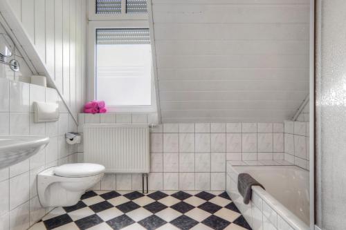 Göckes Haus Und Garten Rosengarten في Wettringen: حمام مع مرحاض ومغسلة وحوض استحمام