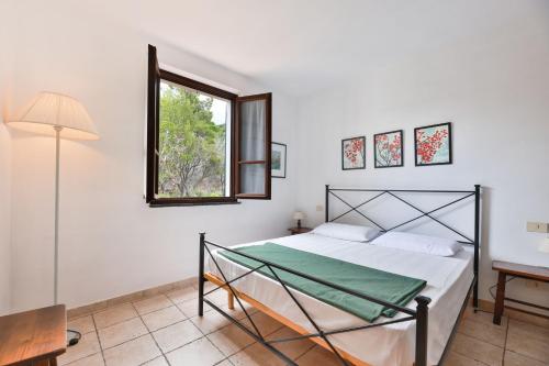 un dormitorio con una cama y una ventana en Cotoncello in una posizione panoramica - Goelba, en Marciana